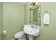 Cozy bathroom with pedestal sink, decorative mirror, and fresh towel at 157 7Th Sw Ave, Largo, FL 33770