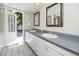 Bright bathroom featuring a double sink vanity and an exterior door to the outdoors at 157 7Th Sw Ave, Largo, FL 33770