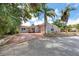 Charming single-story home with well-maintained landscaping, orange doors, and a spacious red-paved driveway at 157 7Th Sw Ave, Largo, FL 33770