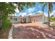 Inviting single-story home with a unique orange door, an extended driveway, and beautiful desert landscaping at 157 7Th Sw Ave, Largo, FL 33770