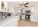 Modern kitchen featuring white cabinets, stainless steel appliances, and a stylish ceiling fan at 157 7Th Sw Ave, Largo, FL 33770