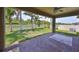 Covered patio overlooking a fenced backyard with lush greenery and lake views at 1612 Cabbage Key Dr, Ruskin, FL 33570