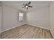 Neutral bedroom features a window, ceiling fan, and wood-look flooring at 1612 Cabbage Key Dr, Ruskin, FL 33570