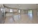 Open-concept kitchen and living room featuring an island, tile flooring, and sliding glass doors to the lanai at 1612 Cabbage Key Dr, Ruskin, FL 33570