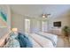Bedroom boasts a ceiling fan and ensuite access; furnished with blue bedding, a dresser and a tv at 1612 Cabbage Key Dr, Ruskin, FL 33570