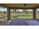 Covered patio with brick flooring and ceiling fan offering a serene view of the pond, trees, and backyard at 1612 Cabbage Key Dr, Ruskin, FL 33570
