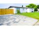 Exterior side view of home with a fenced yard, driveway, and well-maintained landscaping at 1741 Fairfield St, Holiday, FL 34691