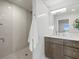 This bathroom features a walk-in shower with a patterned tile wall and a vanity with storage space at 2087 Edgewater Dr # C, Clearwater, FL 33755