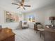 This carpeted bedroom features two abstract paintings, a window with natural light, and a ceiling fan at 2087 Edgewater Dr # C, Clearwater, FL 33755
