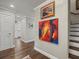 Hallway features hardwood floors, elegant wall art, and access to the stairs at 2087 Edgewater Dr # C, Clearwater, FL 33755