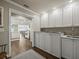 Well-lit laundry room with ample white cabinets and a stainless steel countertop at 2087 Edgewater Dr # C, Clearwater, FL 33755
