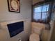 A simple bathroom with a standard toilet and framed artwork on the wall at 2331 Belleair Rd # 904, Clearwater, FL 33764