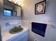 Well-lit bathroom with a green sink, framed artwork, and a towel bar at 2331 Belleair Rd # 904, Clearwater, FL 33764