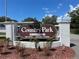 Entrance to a 55+ community called Country Park with sign, landscaping, and an American flag, indicating a welcoming atmosphere at 2331 Belleair Rd # 904, Clearwater, FL 33764
