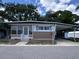 Charming single-story home with a carport, landscaped entrance, and mature trees provides plenty of shade at 2331 Belleair Rd # 904, Clearwater, FL 33764