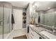 Bright bathroom with a dual sink vanity, granite countertops, a walk-in shower, and modern fixtures at 2511 N Grady Ave # 82, Tampa, FL 33607