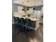 Modern kitchen with gray counter stools, white cabinets, stainless steel appliances, and stylish pendant lighting at 2511 N Grady Ave # 82, Tampa, FL 33607