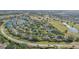 Elevated view of homes with blue tarps on the roofs in a verdant residential area near a lake at 2529 Lancaster Dr, Sun City Center, FL 33573