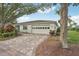 Inviting home exterior with a paved driveway, lush greenery, and a spacious two-car garage, perfect for families at 2529 Lancaster Dr, Sun City Center, FL 33573