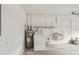 A utility room with water heater, washing machine, a sink, and exposed pipes at 2529 Lancaster Dr, Sun City Center, FL 33573