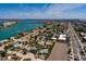 An aerial view features a light-blue home in a coastal neighborhood, set against a backdrop of waterways and city skyline at 340 83Rd Ave, St Pete Beach, FL 33706