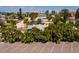 Aerial view of a lovely single-story home with tropical landscaping in a coastal community with water views at 340 83Rd Ave, St Pete Beach, FL 33706