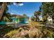 Spacious backyard of a turquoise home with a carport, framed by swaying palm trees at 340 83Rd Ave, St Pete Beach, FL 33706