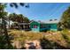 Charming turquoise home with a covered carport and lush palm trees in a sunny setting at 340 83Rd Ave, St Pete Beach, FL 33706