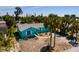 Charming, colorful single-story home with a well-maintained lawn and beautiful, mature palm trees in a tropical setting at 340 83Rd Ave, St Pete Beach, FL 33706