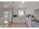 Well-lit kitchen boasts white cabinetry and a view to an outdoor patio at 3491 58Th N St, St Petersburg, FL 33710