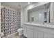 Bright bathroom with a double vanity, modern fixtures, and decorative shower curtain at 35260 Spruce Knob Ct, Dade City, FL 33525