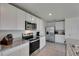 Bright kitchen with stainless steel appliances, white cabinets, granite countertops, and tile flooring at 35260 Spruce Knob Ct, Dade City, FL 33525