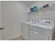 Practical laundry room features modern washer and dryer, with upper shelving for storage at 35260 Spruce Knob Ct, Dade City, FL 33525