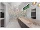 Bright bathroom featuring marble shower, double sink vanity, with marble countertops and floors at 3604 W El Prado Blvd, Tampa, FL 33629