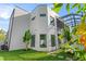 Modern home with clean lines and a lush green lawn enhanced by small palm trees at 3604 W El Prado Blvd, Tampa, FL 33629