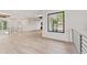 Bright hallway featuring hardwood floors, white walls, metal railings, and a large picture window at 3604 W El Prado Blvd, Tampa, FL 33629