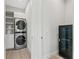 Laundry room with stacked washer/dryer, utility closet, and modern black storage unit at 3604 W El Prado Blvd, Tampa, FL 33629