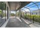 Spacious screened in patio with ceiling fans and lush green scenery at 3604 W El Prado Blvd, Tampa, FL 33629