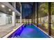 Gorgeous backyard oasis featuring a pristine pool, screened-in lanai, and well-lit landscaping at 3604 W El Prado Blvd, Tampa, FL 33629