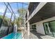 Screened-in pool and outdoor entertaining space with ceiling fans, exterior kitchen, and lush landscaping at 3604 W El Prado Blvd, Tampa, FL 33629