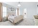 Bright bedroom boasts a decorative bedframe, light-colored walls, and a view of the ensuite bathroom at 3706 Front Park Dr, Wesley Chapel, FL 33543