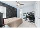 Bedroom with an accent wall, ceiling fan, desk area, and an attached bathroom at 3706 Front Park Dr, Wesley Chapel, FL 33543