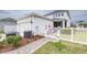 Charming two-story home with a well-manicured lawn, white fence, and inviting walkway at 3706 Front Park Dr, Wesley Chapel, FL 33543