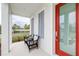 Cozy front porch featuring stylish seating, perfect for enjoying quiet moments outdoors with a red front door at 3706 Front Park Dr, Wesley Chapel, FL 33543