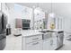 Open concept kitchen with white cabinets, stainless steel appliances, island seating, and open to living at 3706 Front Park Dr, Wesley Chapel, FL 33543