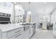 Modern kitchen with white cabinets, stainless steel sink, and view into the breakfast nook and Gathering room at 3706 Front Park Dr, Wesley Chapel, FL 33543