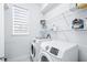 Practical laundry room with side by side washer and dryer and ample storage space at 3706 Front Park Dr, Wesley Chapel, FL 33543