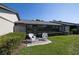 Backyard featuring lush lawn, manicured hedges, sunroom and patio with rocking chairs at 40 Gretchen Ct, Oldsmar, FL 34677