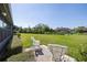 Serene backyard featuring a well-manicured lawn and a patio with two white rocking chairs at 40 Gretchen Ct, Oldsmar, FL 34677