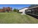 Backyard featuring lush lawn, manicured hedges, sunroom and patio with rocking chairs at 40 Gretchen Ct, Oldsmar, FL 34677